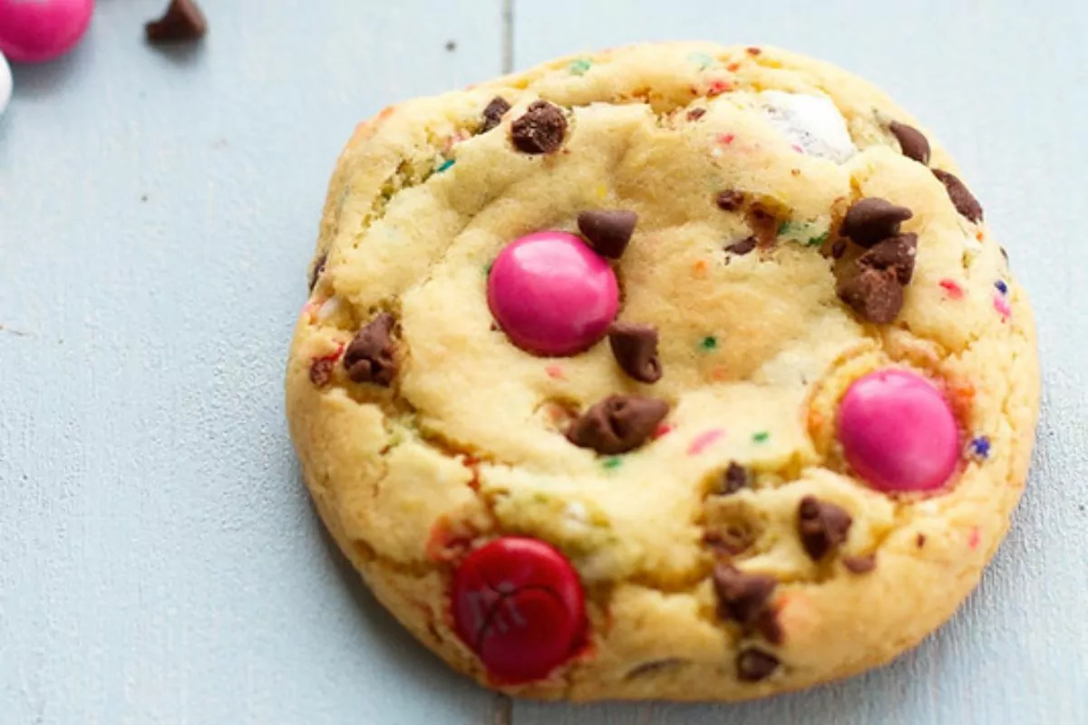 A pile of cookies with sprinkles, candy and cookie crumbs on a plate.