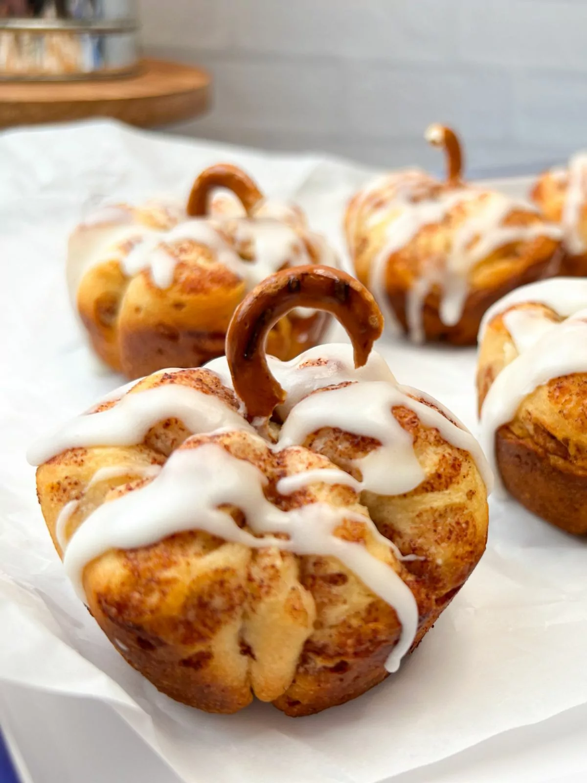 pumpkin shaped rolls with glaze and pretzel stem.