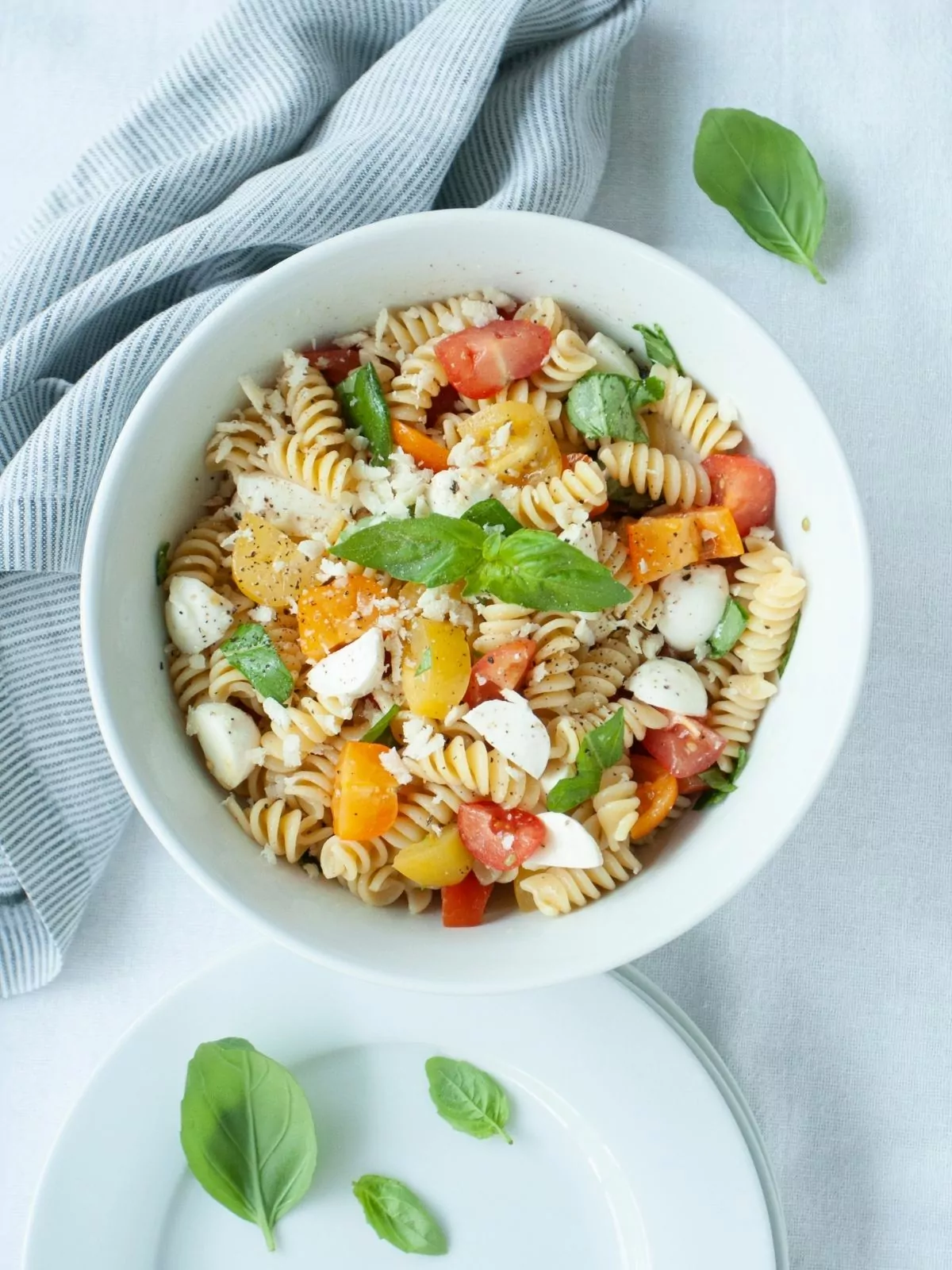 tomato and pasta salad in white bowl.