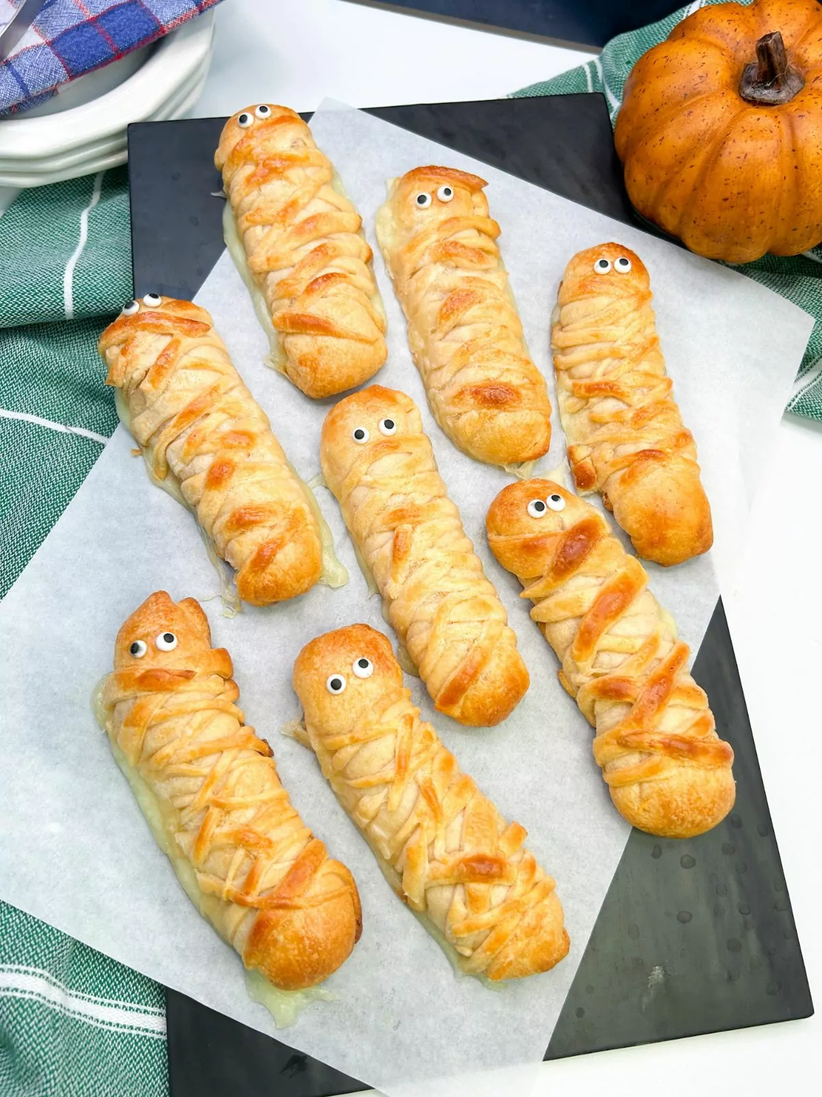 baked mummies on parchment paper and black board.