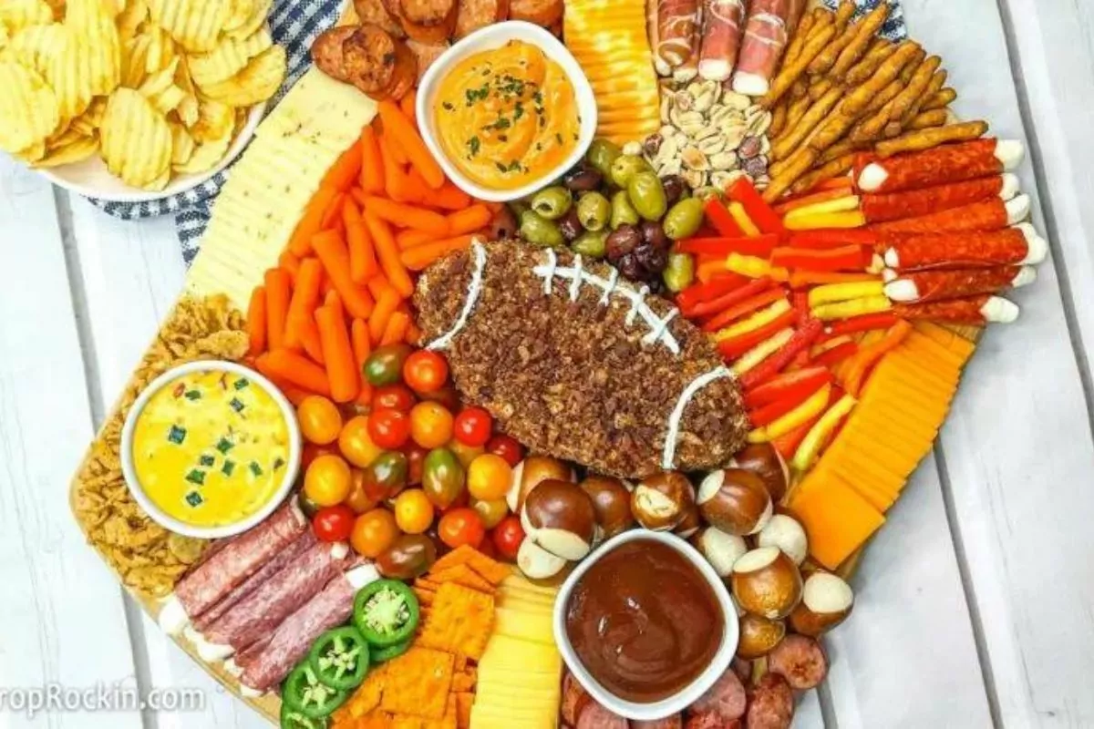 a charcuterie meat, cheese, cheeseball, salty snacks, dips and veggies