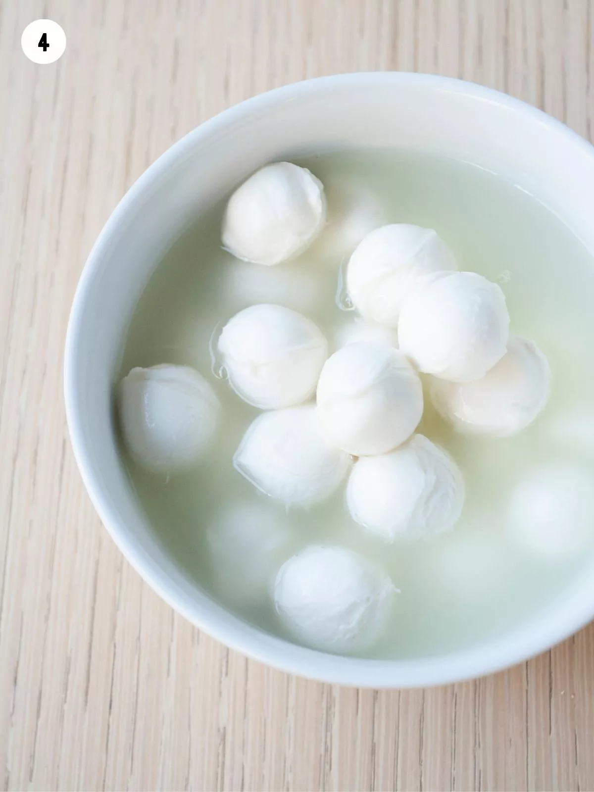 fresh mozzarella balls in white bowl.