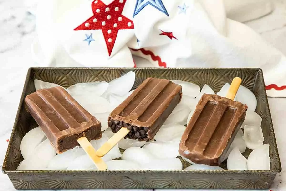 a batch of frozen chocolate fudgesicles in a tray