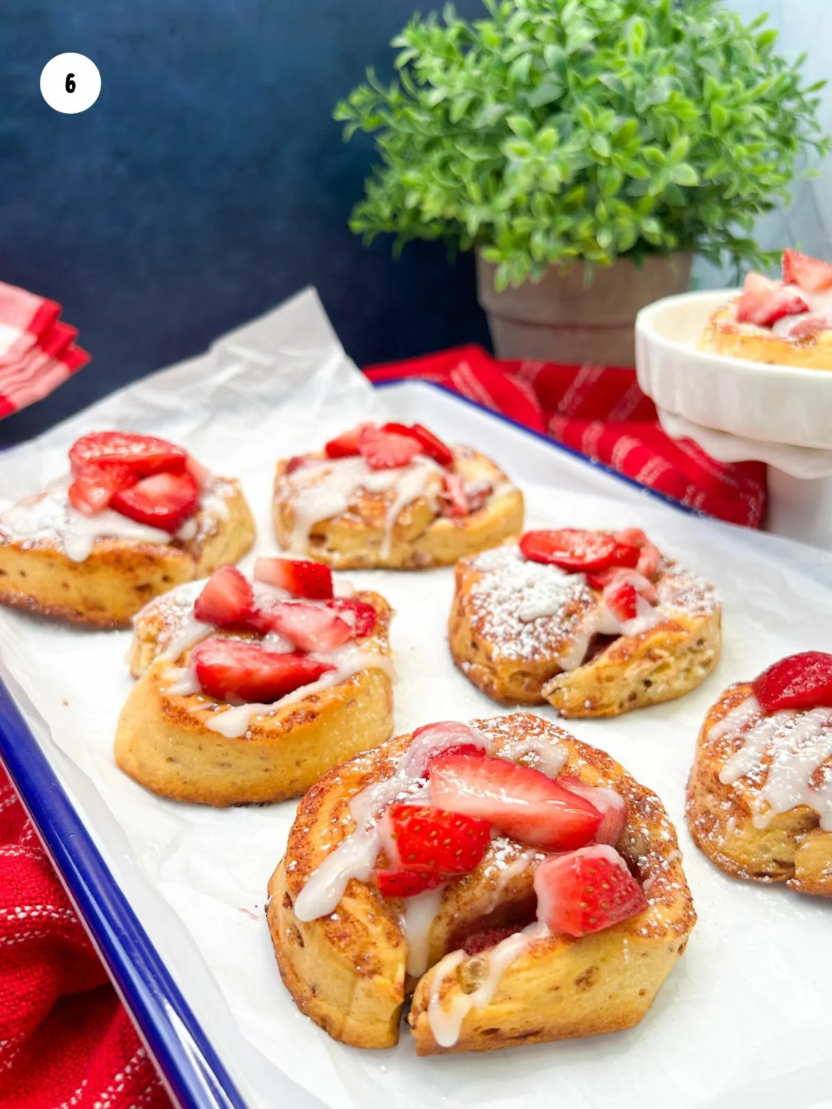 closeup of strawberries spooned on top of baked rolls.