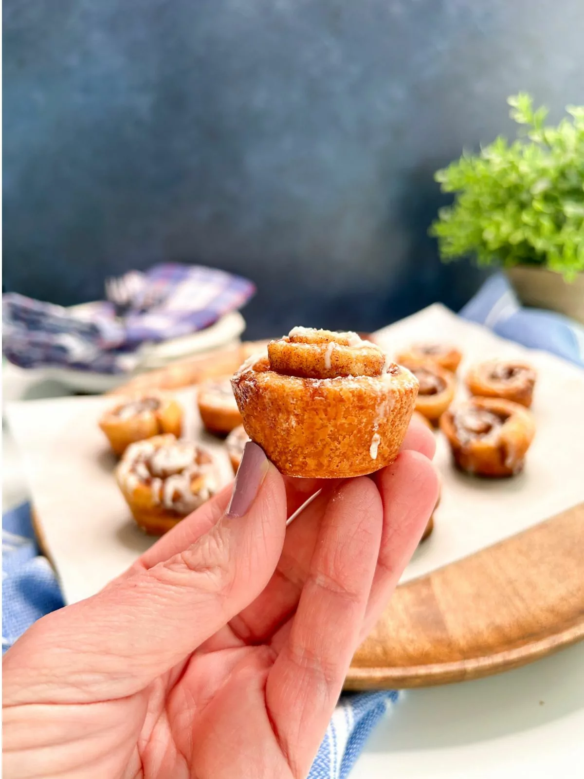 holding a mini cinnamon roll baked.