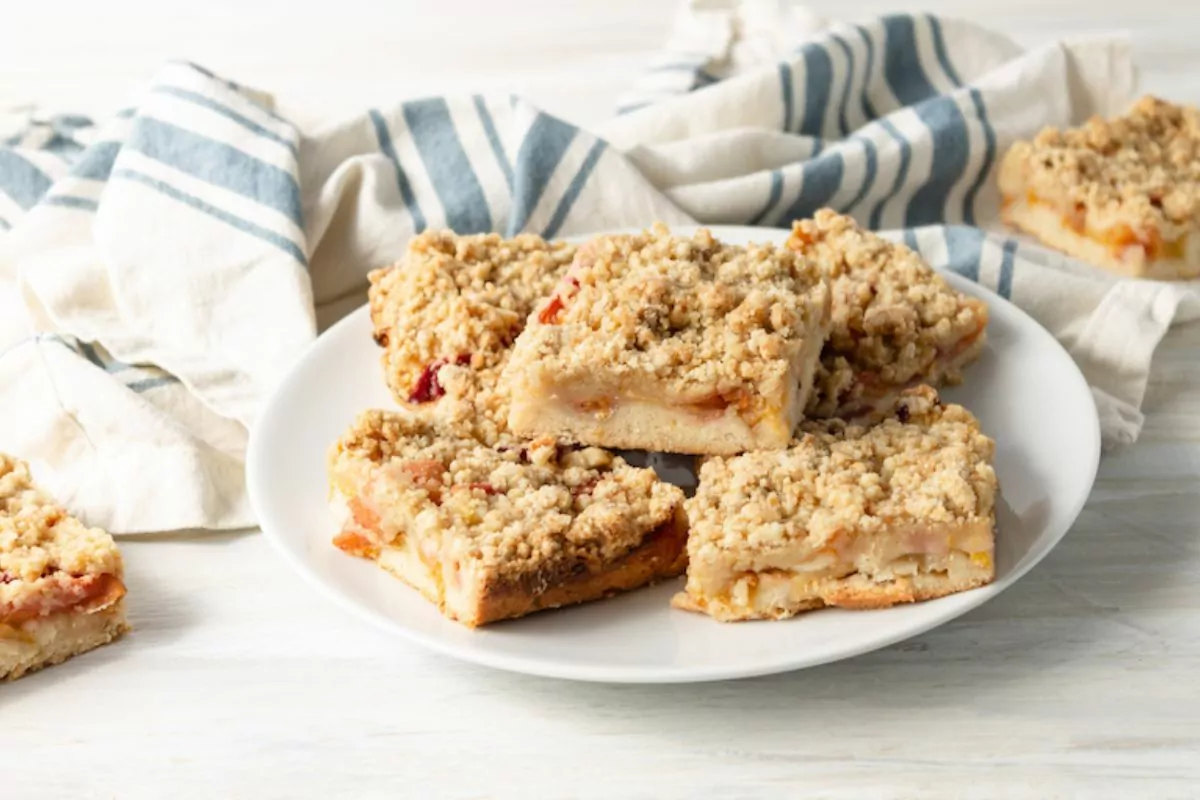 A plate stacked with peach crumb bars with oatmeal crumb topping