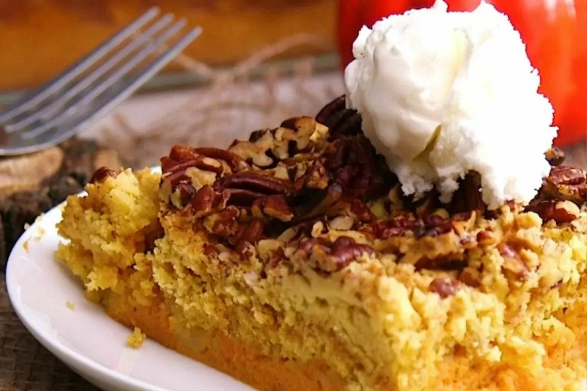 closeup of pumpkin cake with crumb pecan topping and a scoop of vanilla ice cream.