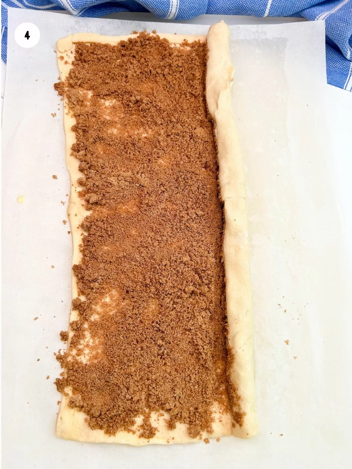 crescent roll dough spread with brown sugar mixture and partly rolled up.