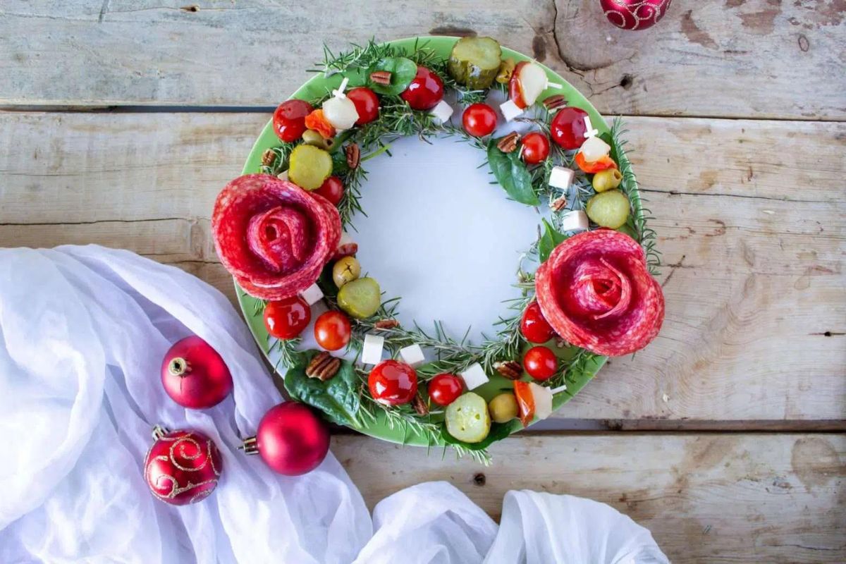 a charcuterie wreath with salami roses, pickle chunks and tomatoes