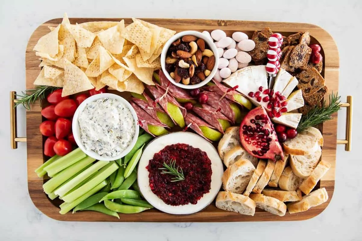 a charcuterie board with cured meats, cheeses, dips, fruits and nuts,