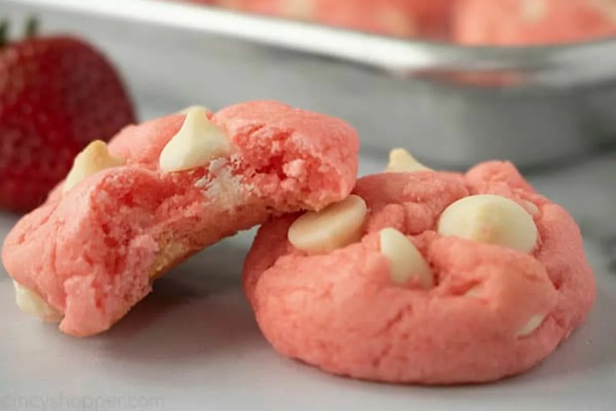 Two pink cookies with white chocolate chips.