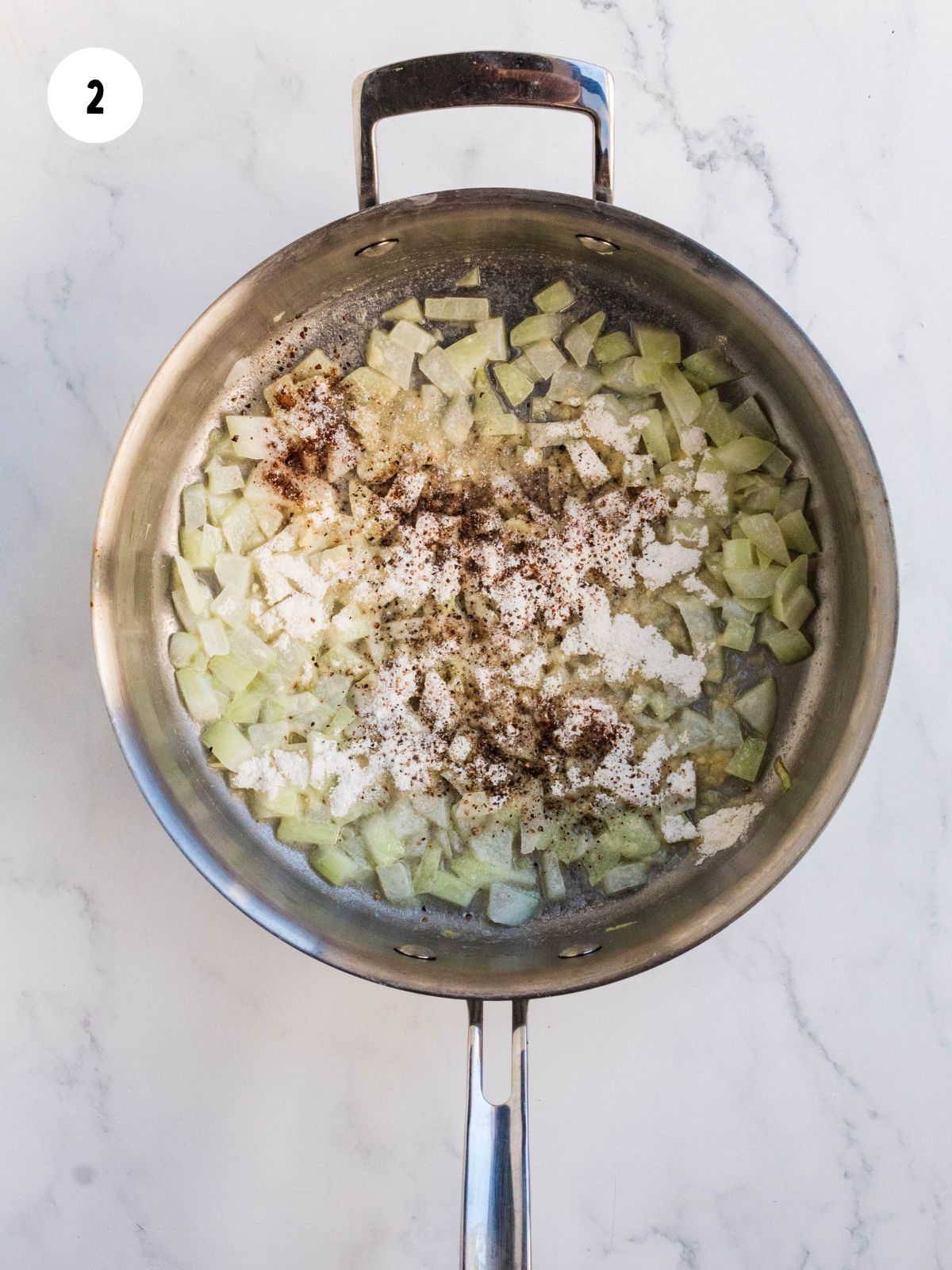 Flour, salt, pepper, and nutmeg sprinkled over the onions