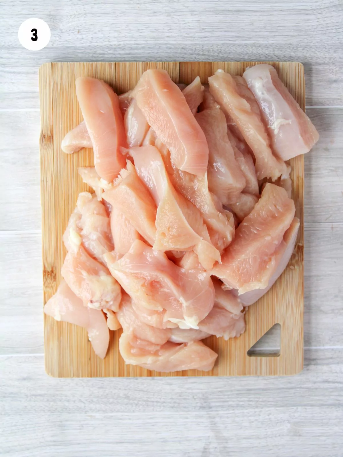 chicken breast cut into strips on a cutting board