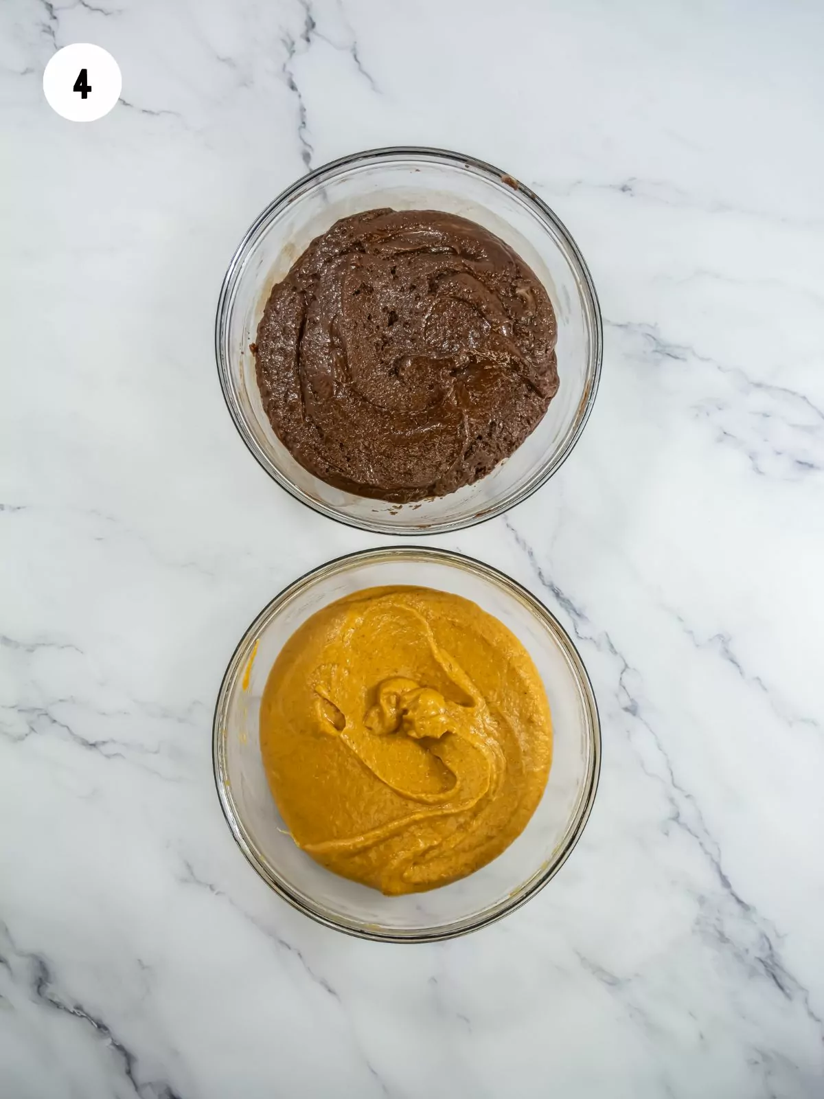 chocolate brownie batter in the top bowl and pumpkin brownie batter in the bottom bowl