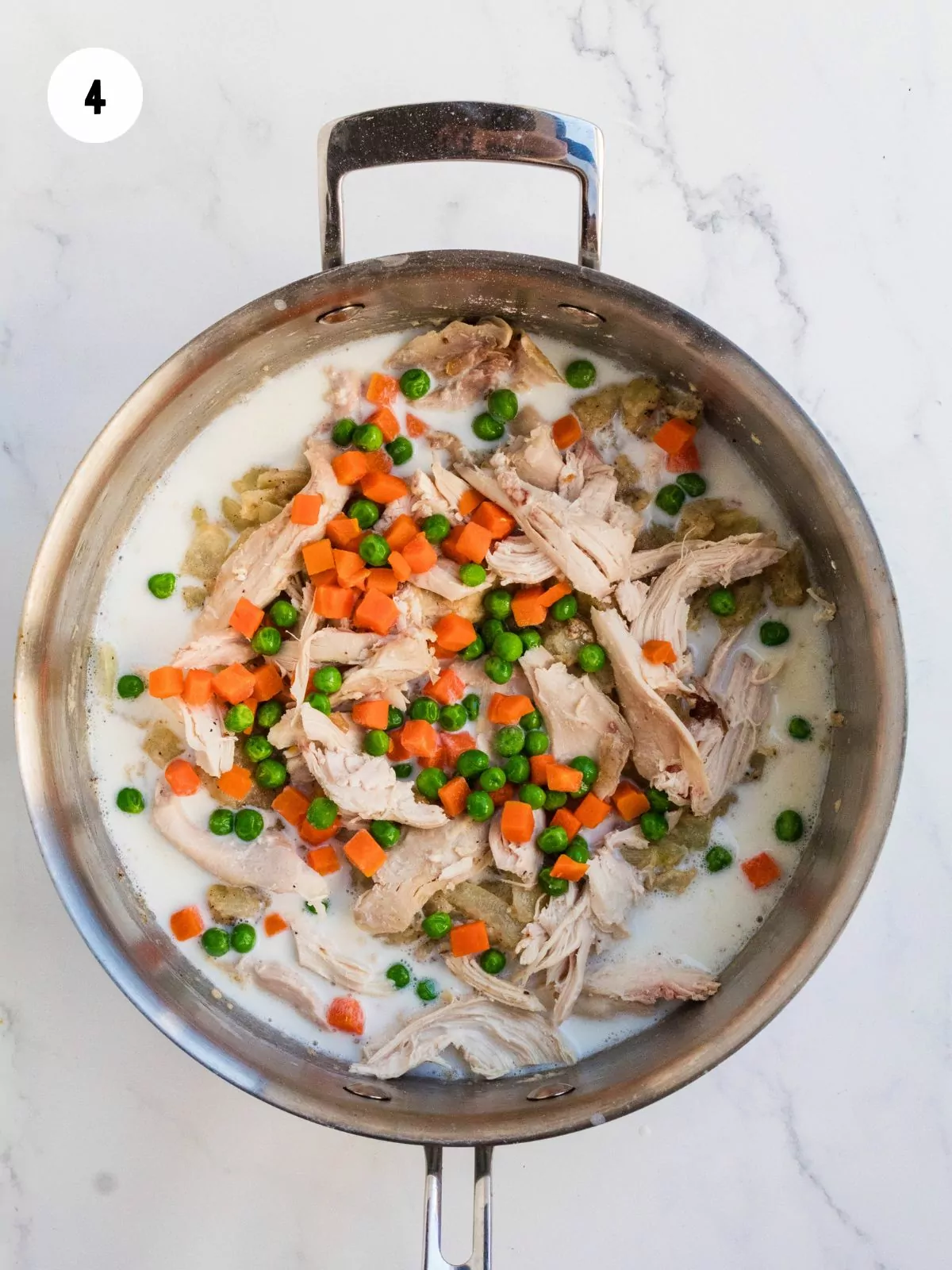 shredded chicken, peas and carrots added to the pan