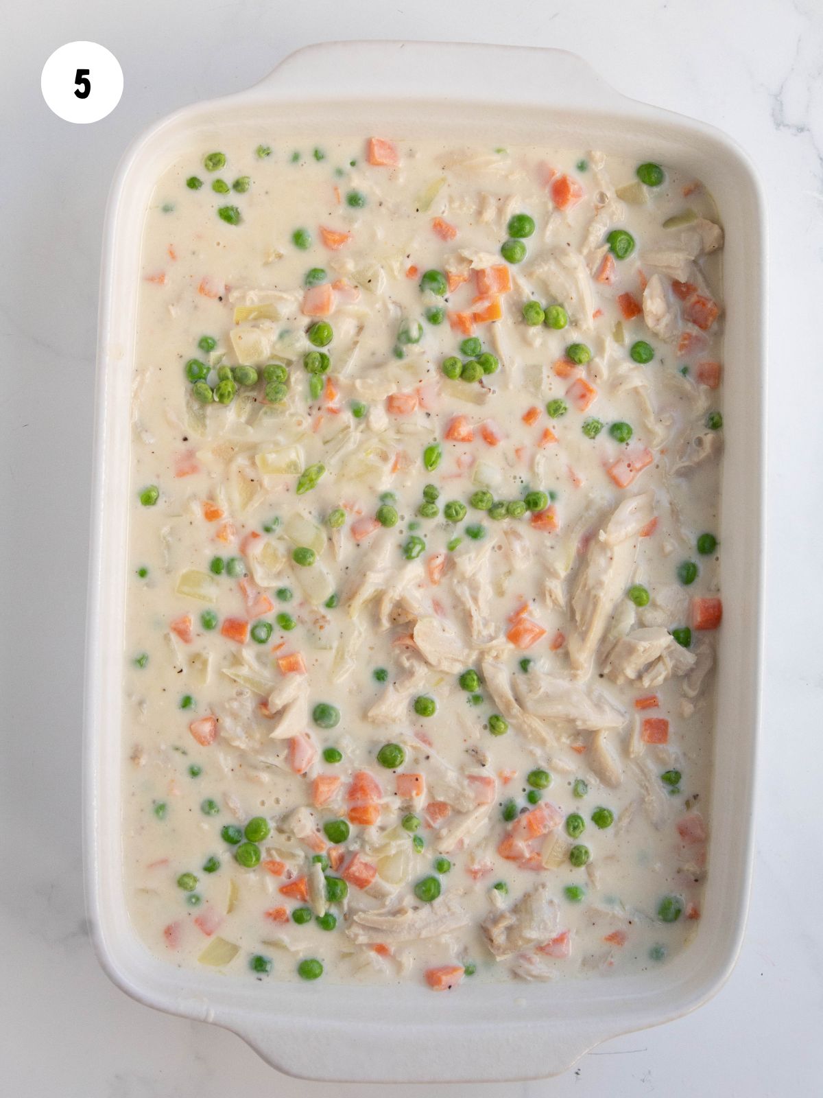 pot pie mixture added to a white casserole dish