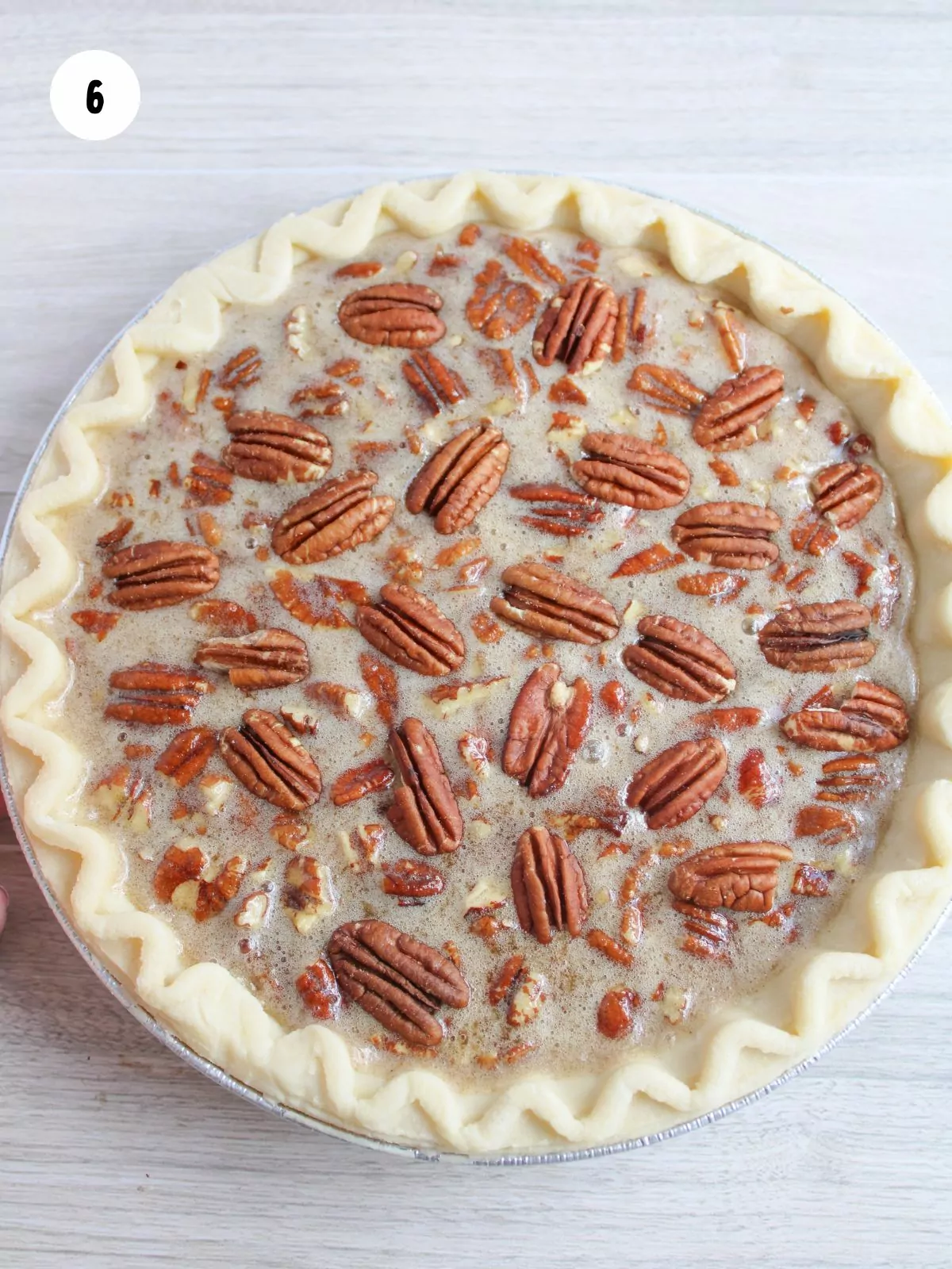 halved pecans added to the top of the unbaked pie