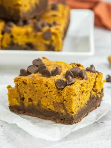 Pumpkin Brownie on a square of parchment with a platter in the background