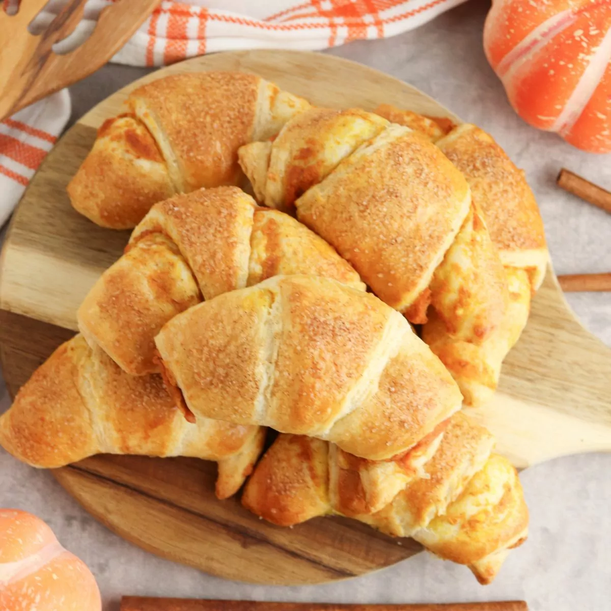 Pumpkin Cream Cheese Crescents piled onto a round wooden board