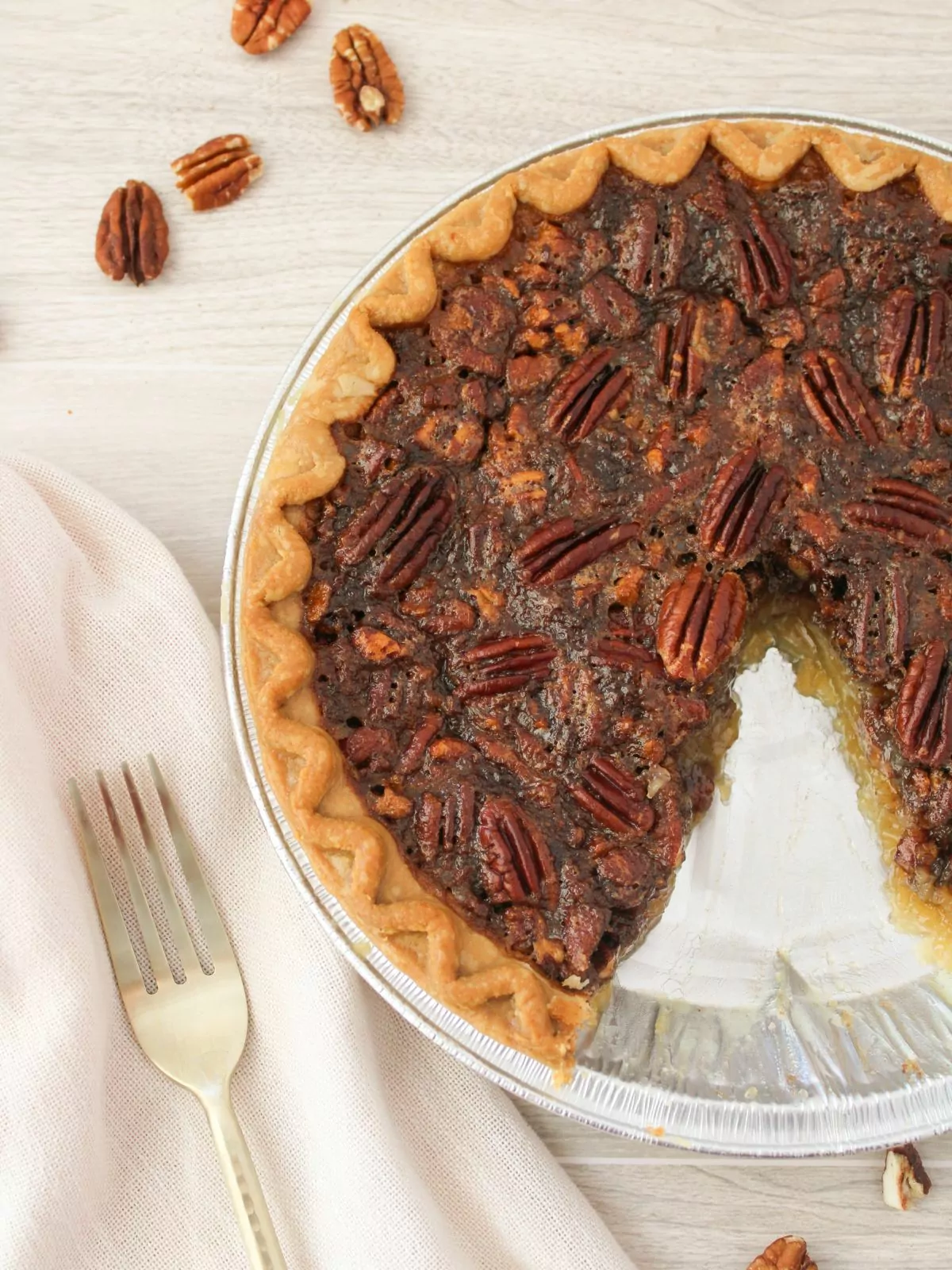 pecan pie with a slice removed and a fork next to the pie