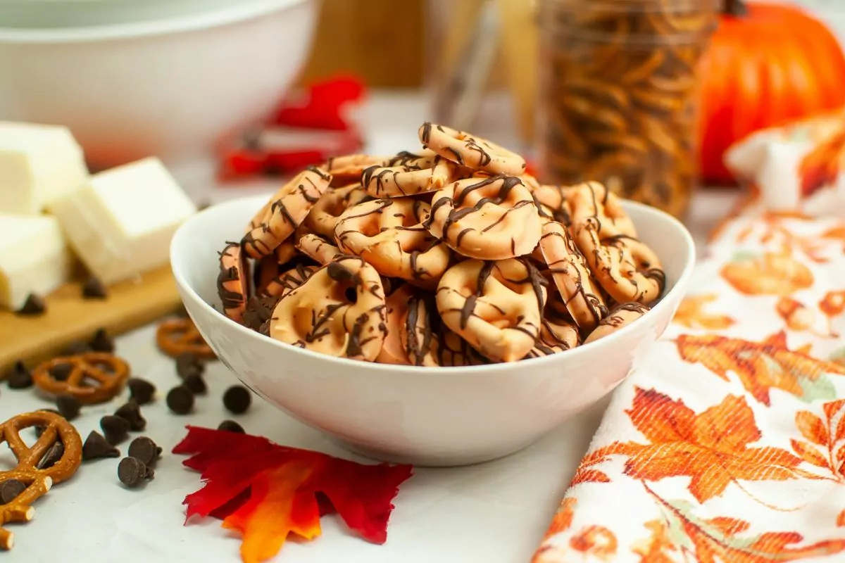 bowl of chocolate covered pretzels with mason jar of pretzel twists in background.