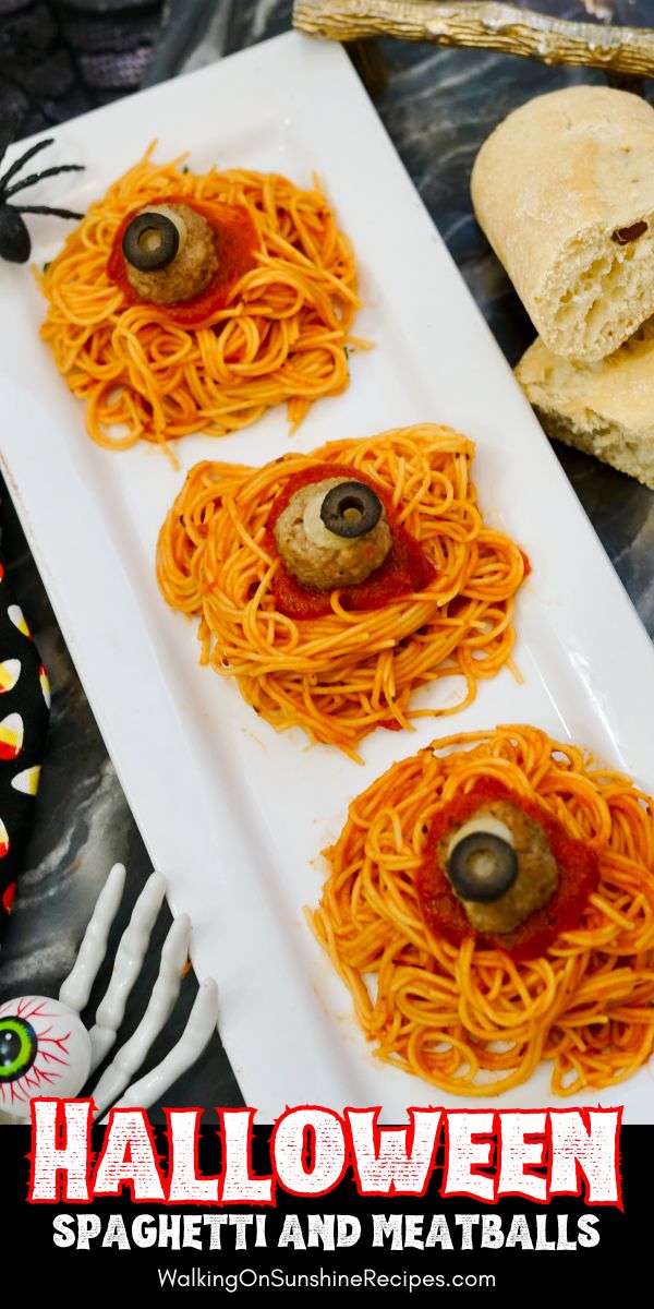 3 mounds of spaghetti on white platter with meatballs decorated like eyeballs for Halloween.