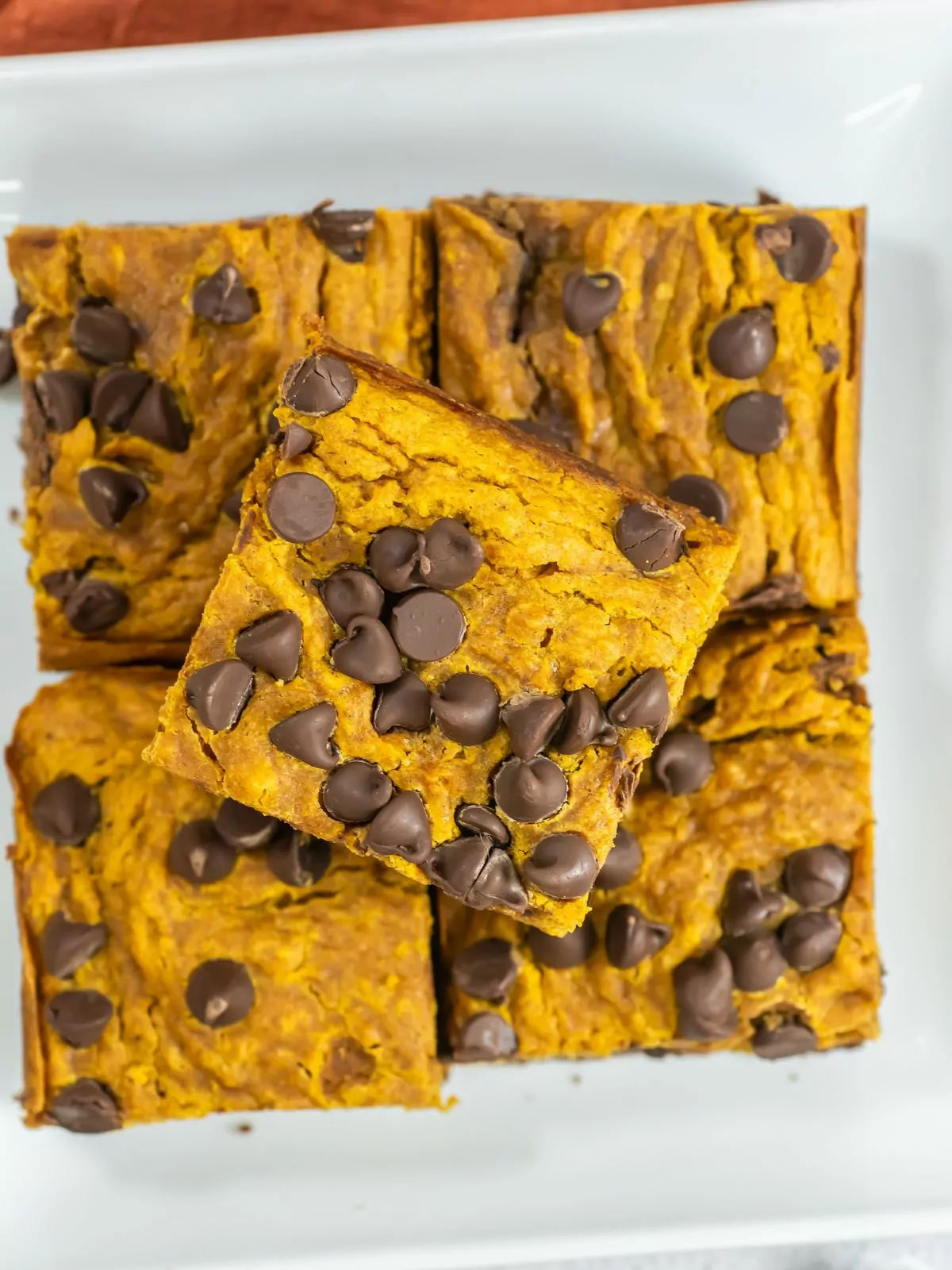 overhead view of pumpkin brownies with chocolate chips cut into squares