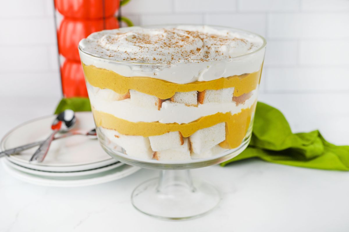 Pumpkin Trifle Dessert with dessert plates and spoons stacked in the background