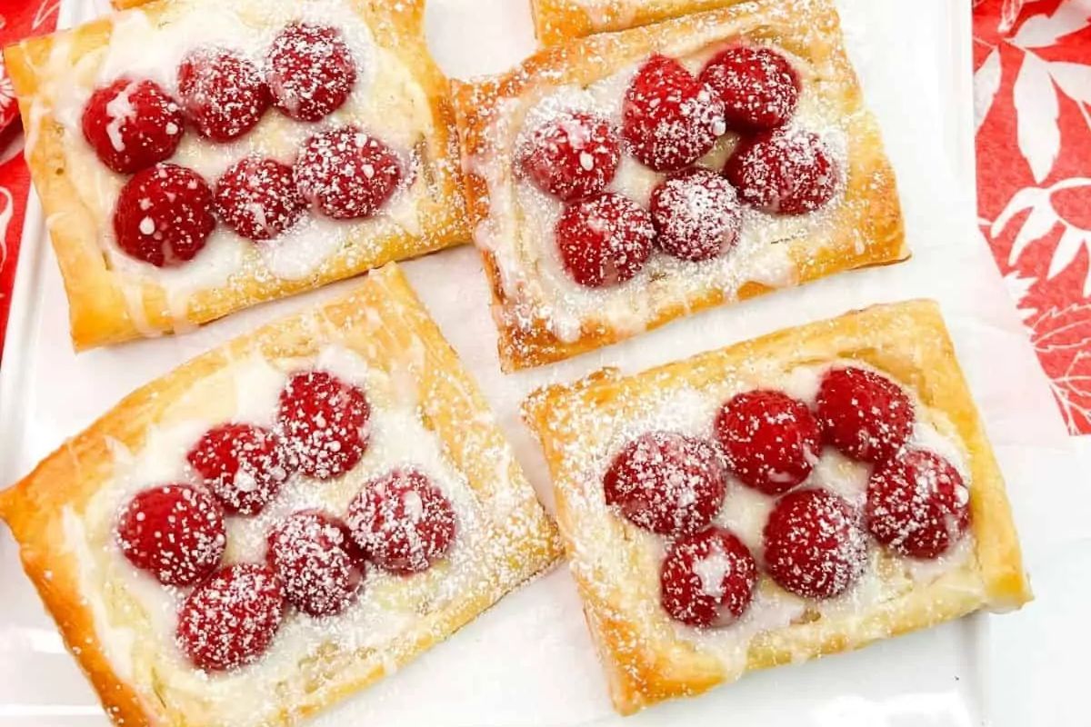 puff pastry Danish with cream cheese filling, fresh raspberries and a powdered sugar glaze toppings