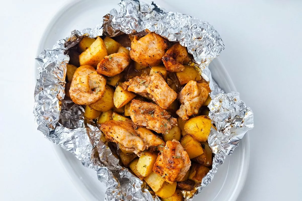 a plate of foil pack potato and chicken