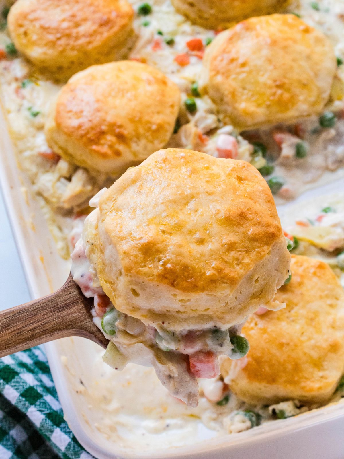 scoop of biscuit chicken pot pie on a wooden spoon