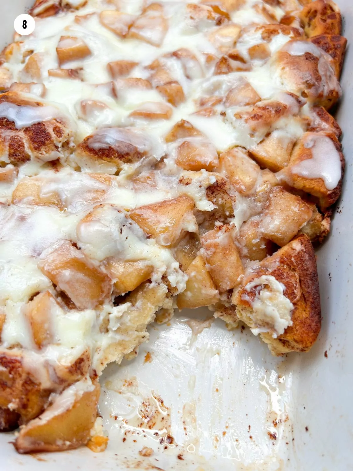 close up of baked cinnamon roll casserole with apples.