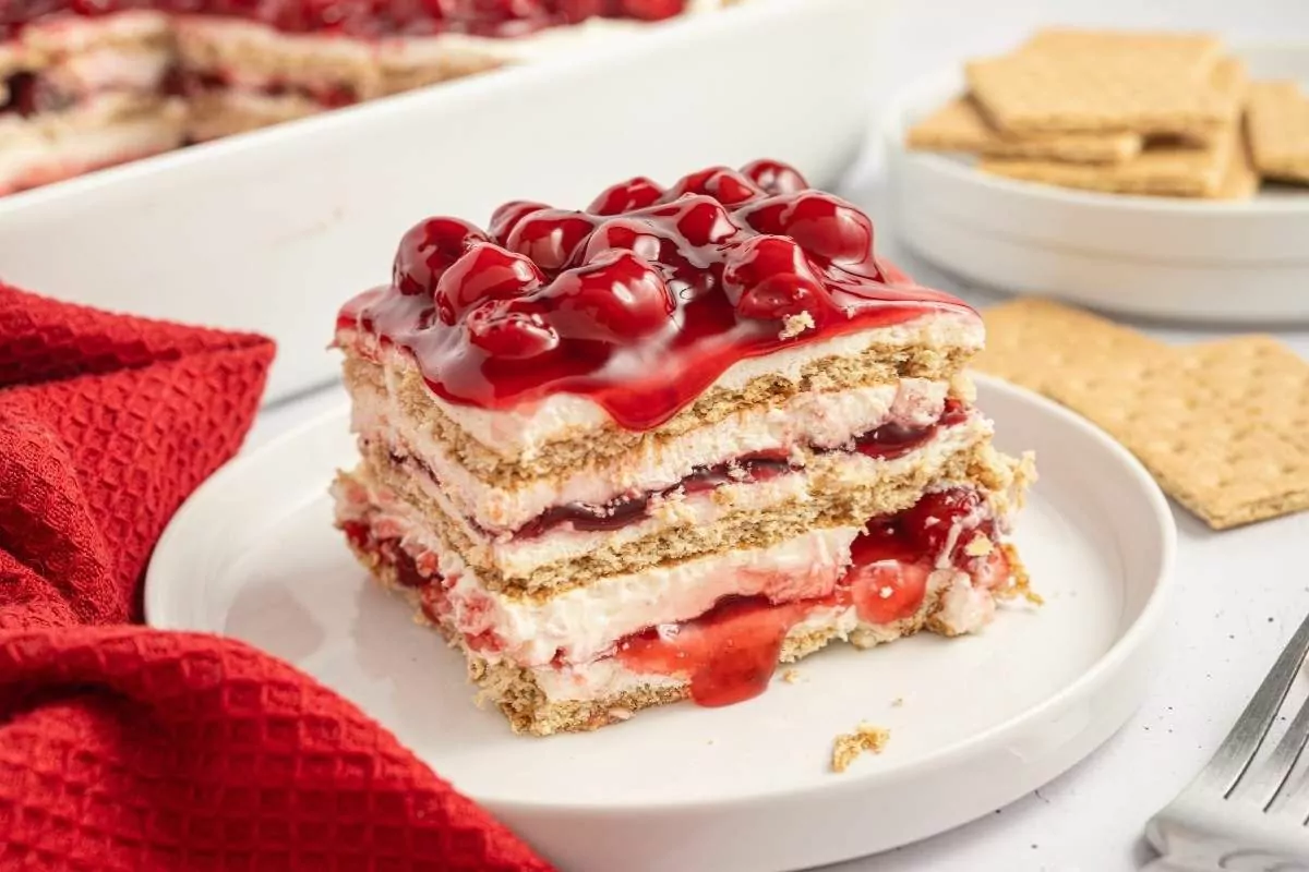 a plate of icebox cake with strawberry filling and topping