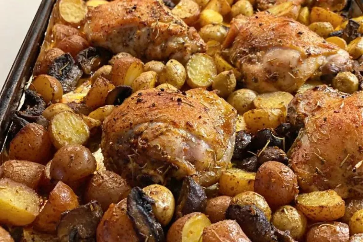 a sheet pan of bake chicken thigh with potatoes and mushroom