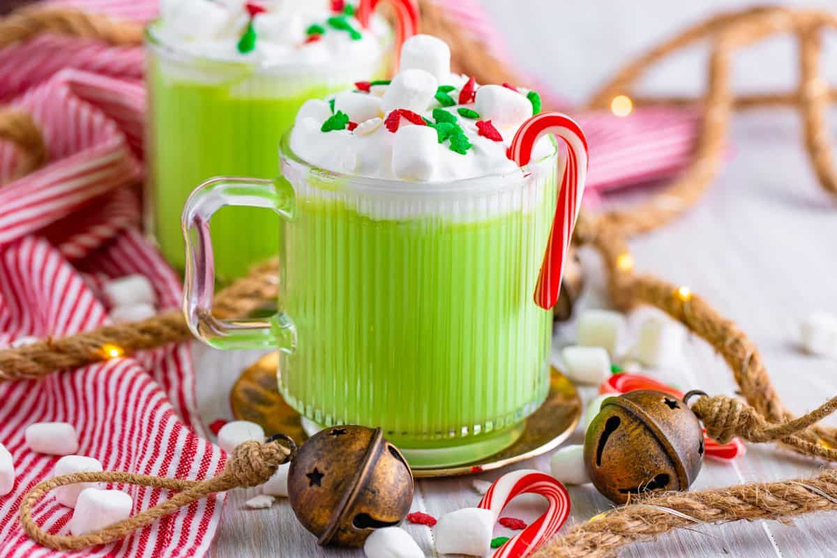 a mug of green hot chocolate with whipped cream marshmallows and sprinkles