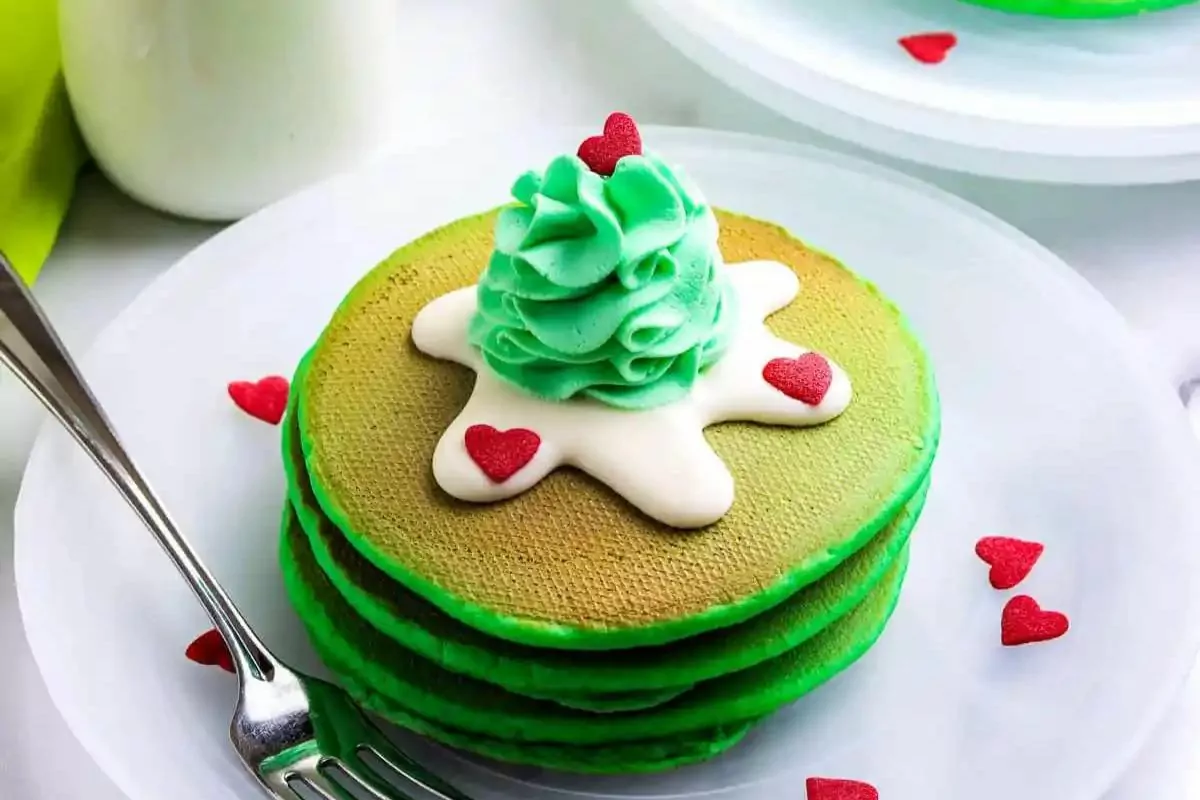 green pancake with icing on top and heart sprinkles