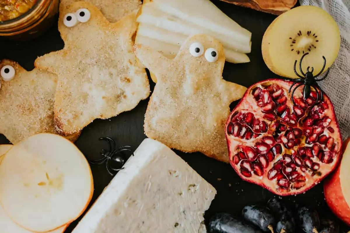 Halloween Cheese Board, with homemade jalapeño jelly and adorable cinnamon-sugar buñuelo ghosts