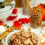 Bowl of pretzel twists dipped in orange colored chocolate.