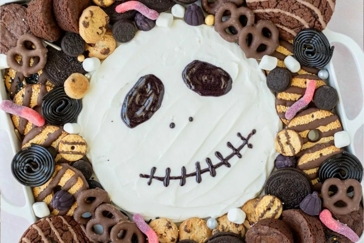 skull face Halloween Sweets Charcuterie Board with cookies, pretzel brownies and gummy worm