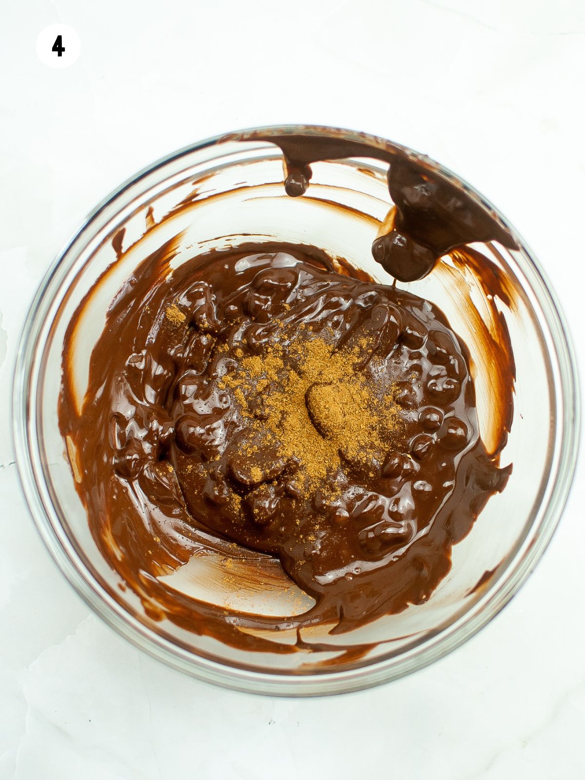 bowl of melted chocolate with pumpkin pie spice sprinkled on top.