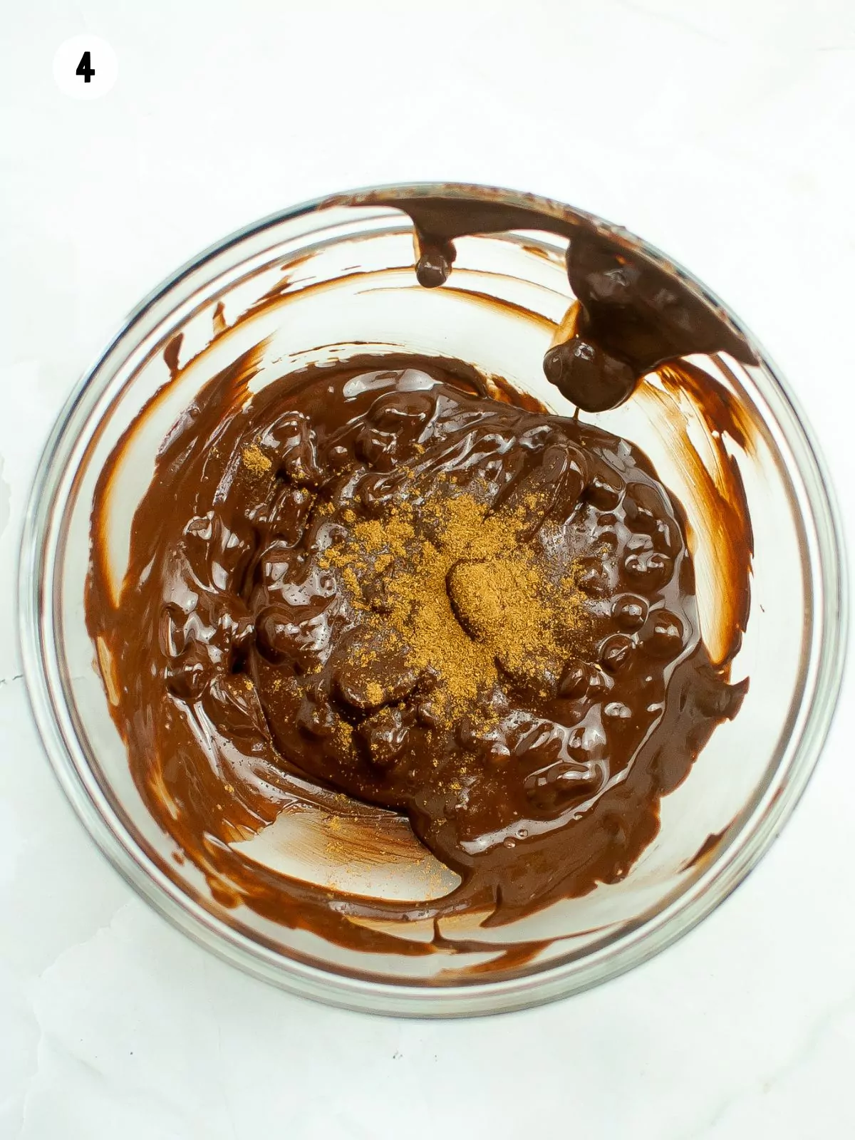 bowl of melted chocolate with pumpkin pie spice sprinkled on top.