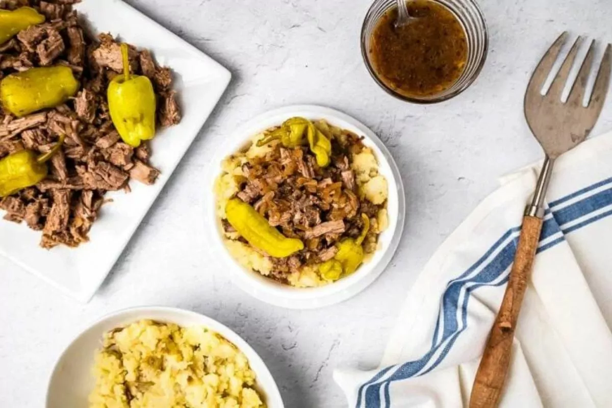 a bowl of mashed potato with beef beef pepper and gravy toppings