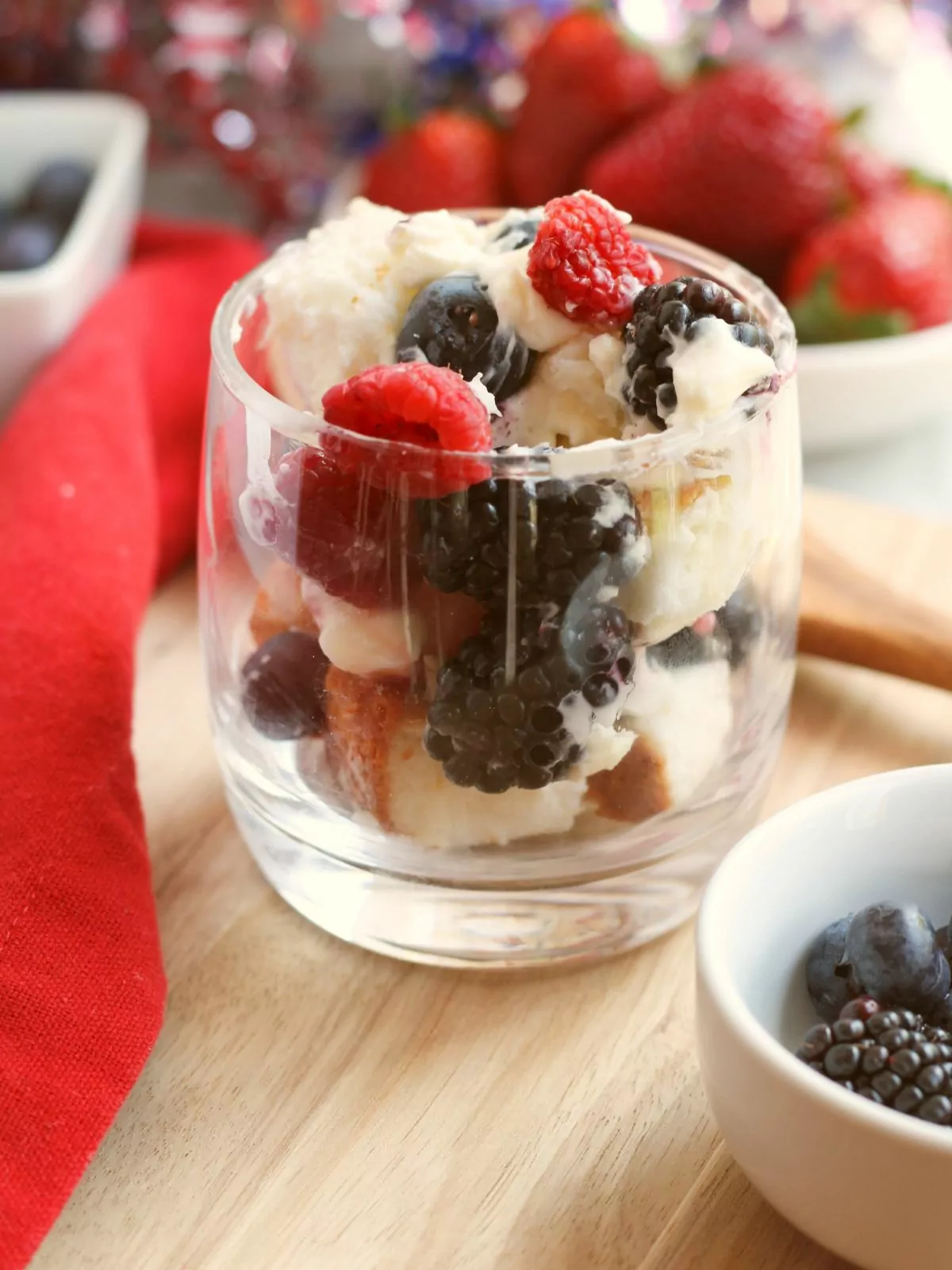 glass with angel food cake, berries and whipped cream.