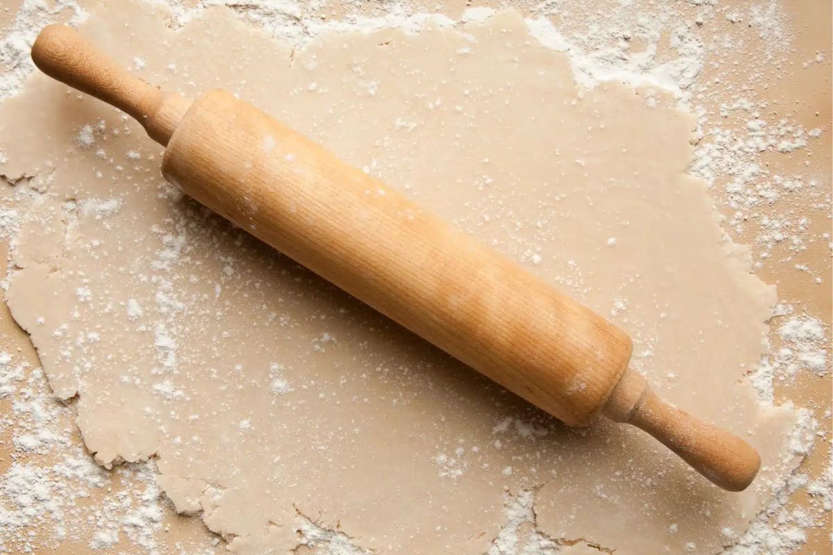 pie dough rolled out with rolling pin on top.