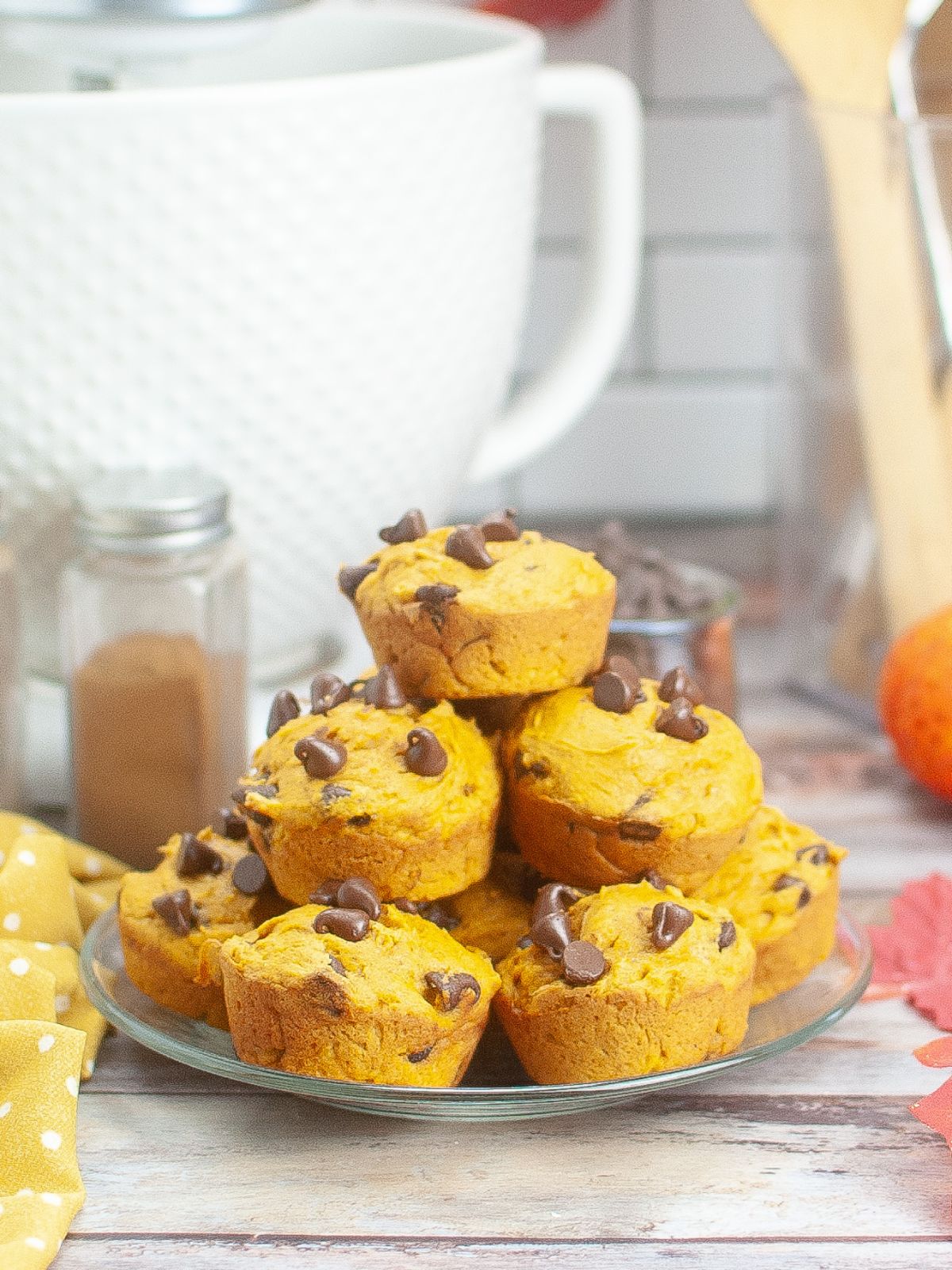 pumpkin chocolate chip muffins piled on a clear plate