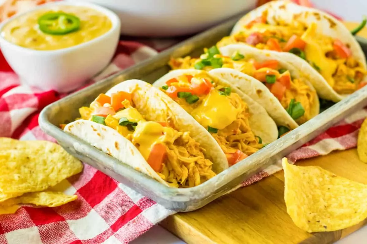 a plate of four cheesy tacos