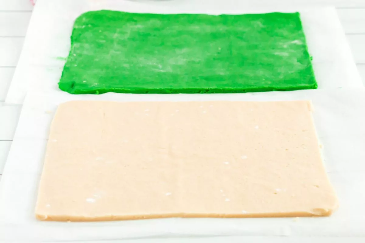 2 sheets of cookie dough rolled out into rectangles. One is green, the other is vanilla.