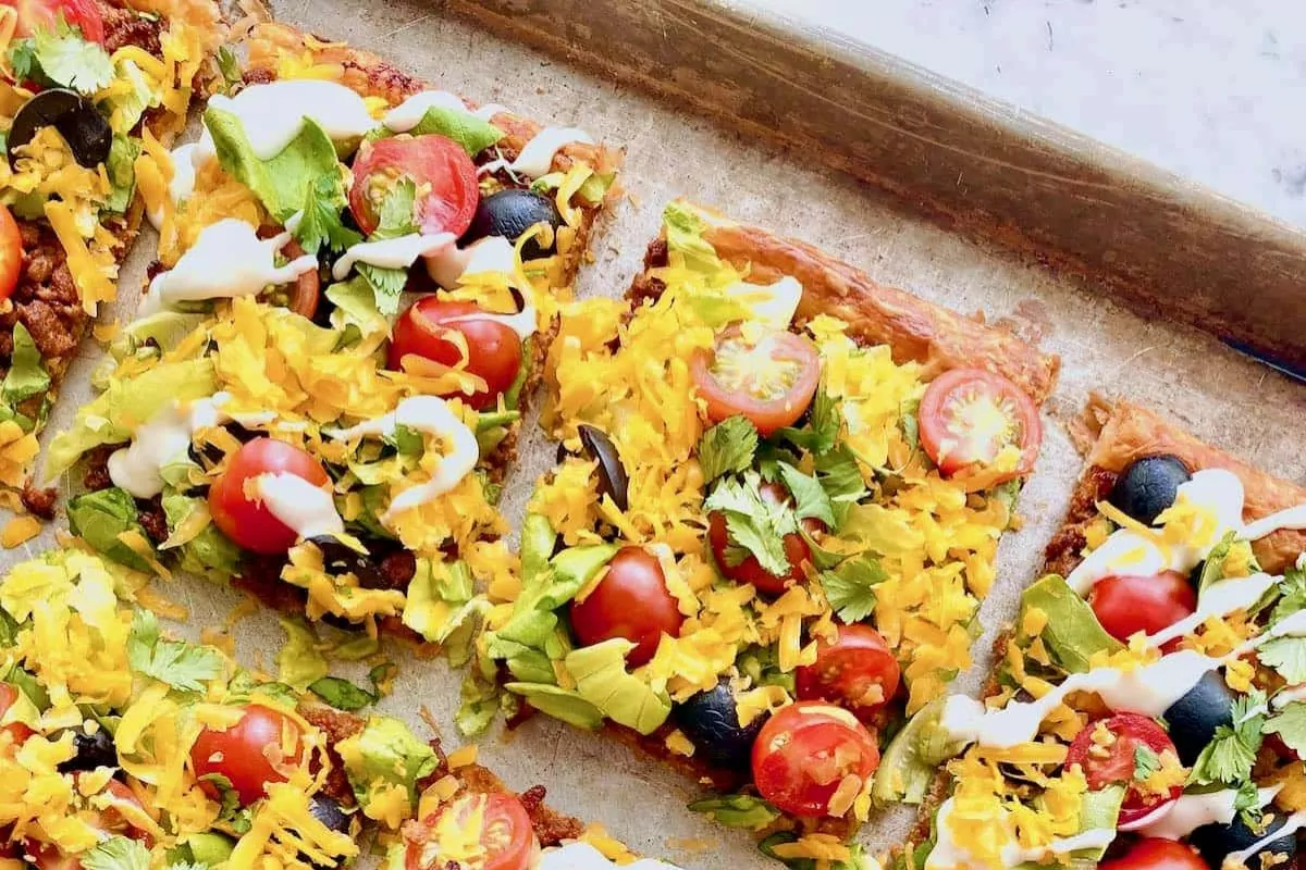 puff pastry and shapes it into a flaky crust, then piles all of the taco toppings