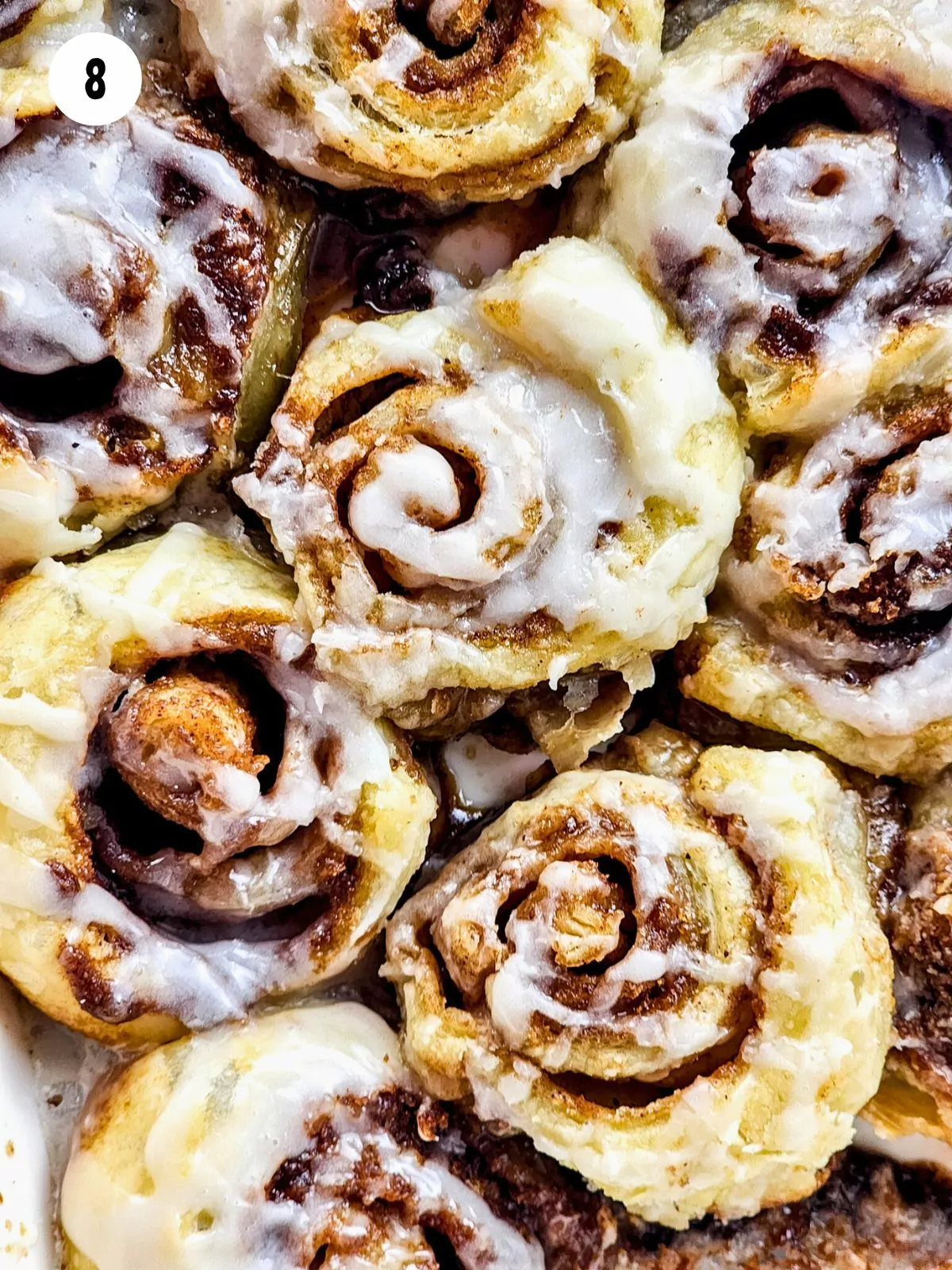 closeup of cinnamon rolls with powdered sugar glaze.