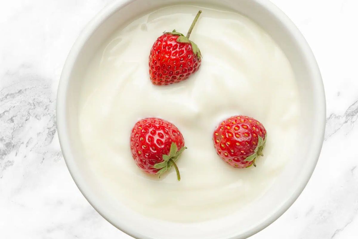 bowl of plain yogurt with strawberries.